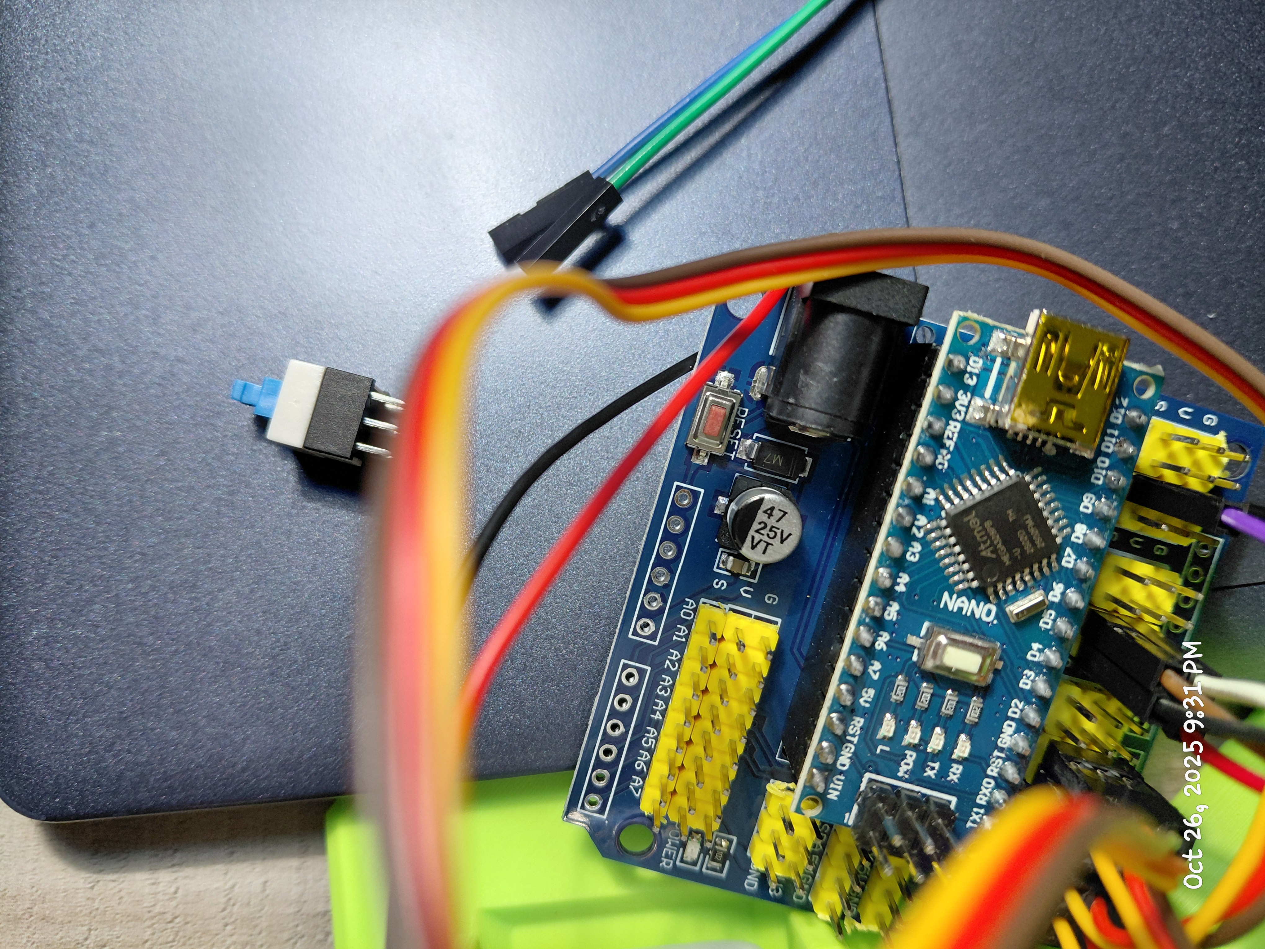 Arduino Nano on a blue shield with jumper wires on a work surface