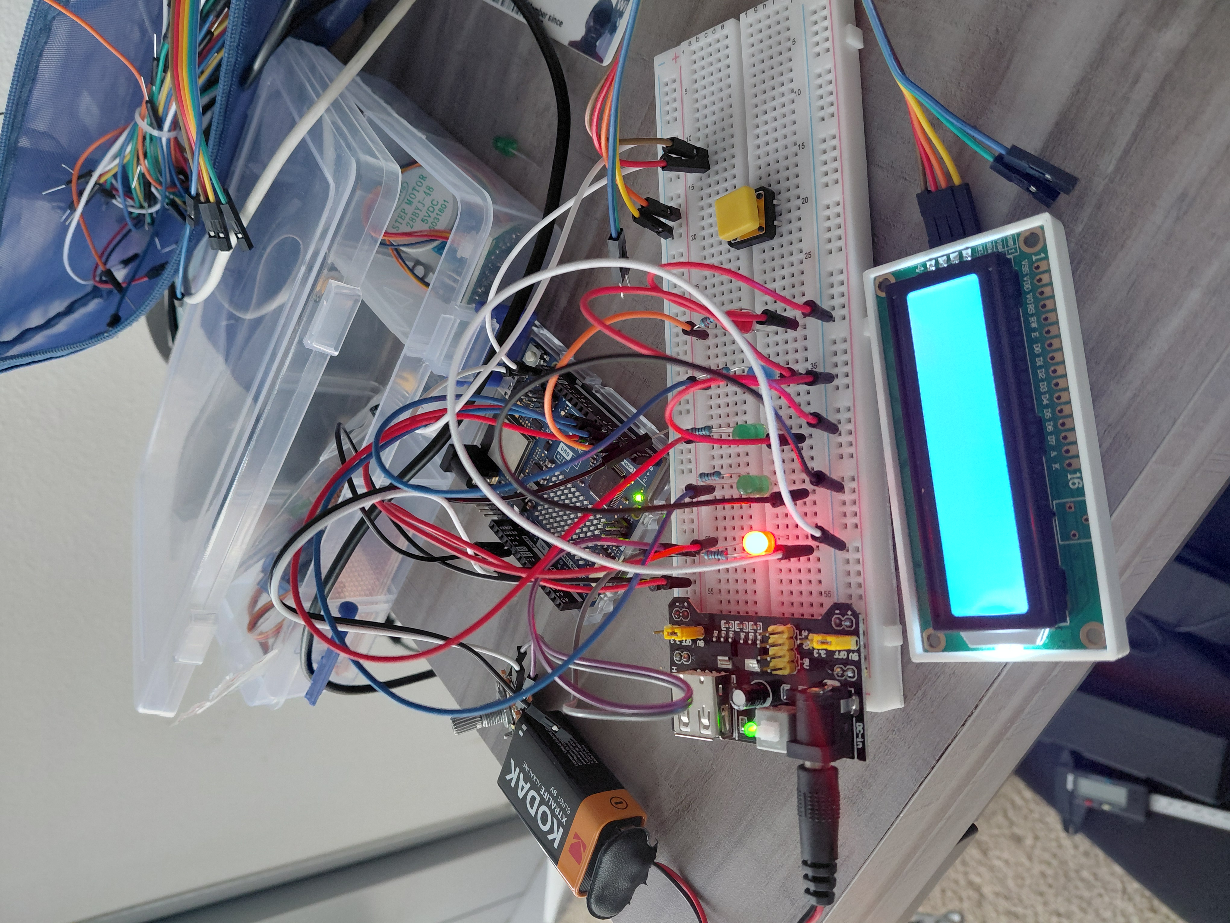 Breadboard with Arduino, LCD display, LEDs, and jumper wires on a desk